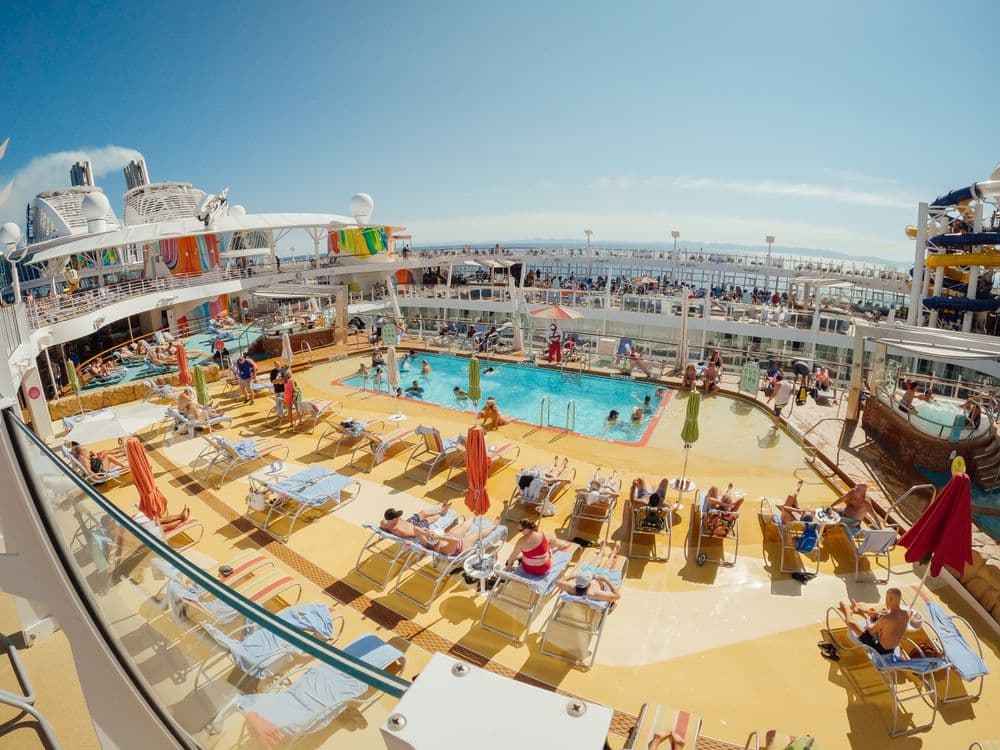 Passengers relaxing by the pool on a cruise ship deck